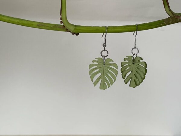 Acrylic monstera leaf earring hanging, in moss green