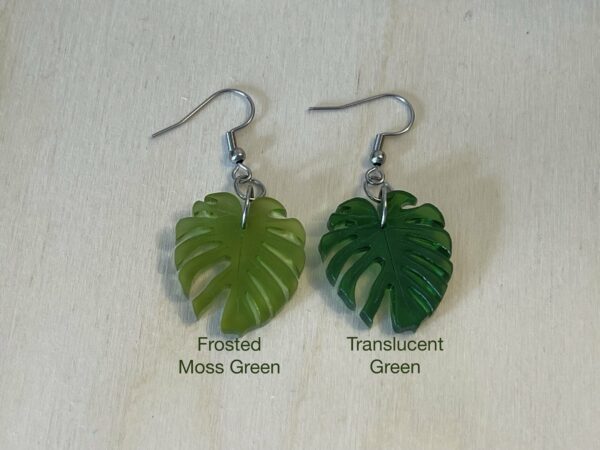 Acrylic monstera leaf dangle earrings in two shades of green with labels