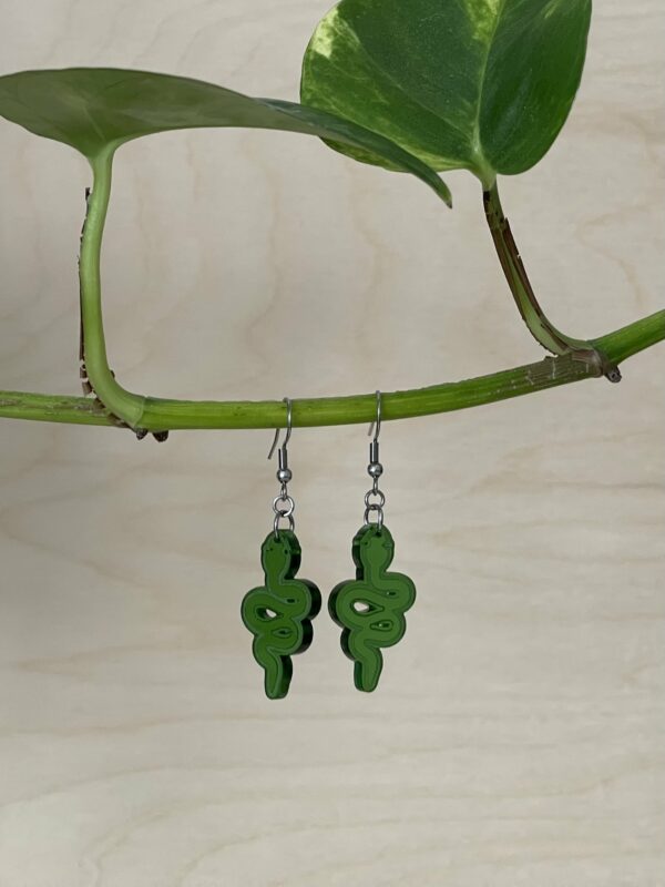 Acrylic translucent green snake dangle earrings, hanging from branch