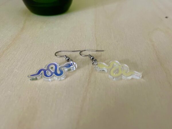 Acrylic snake dangle earrings lying flat